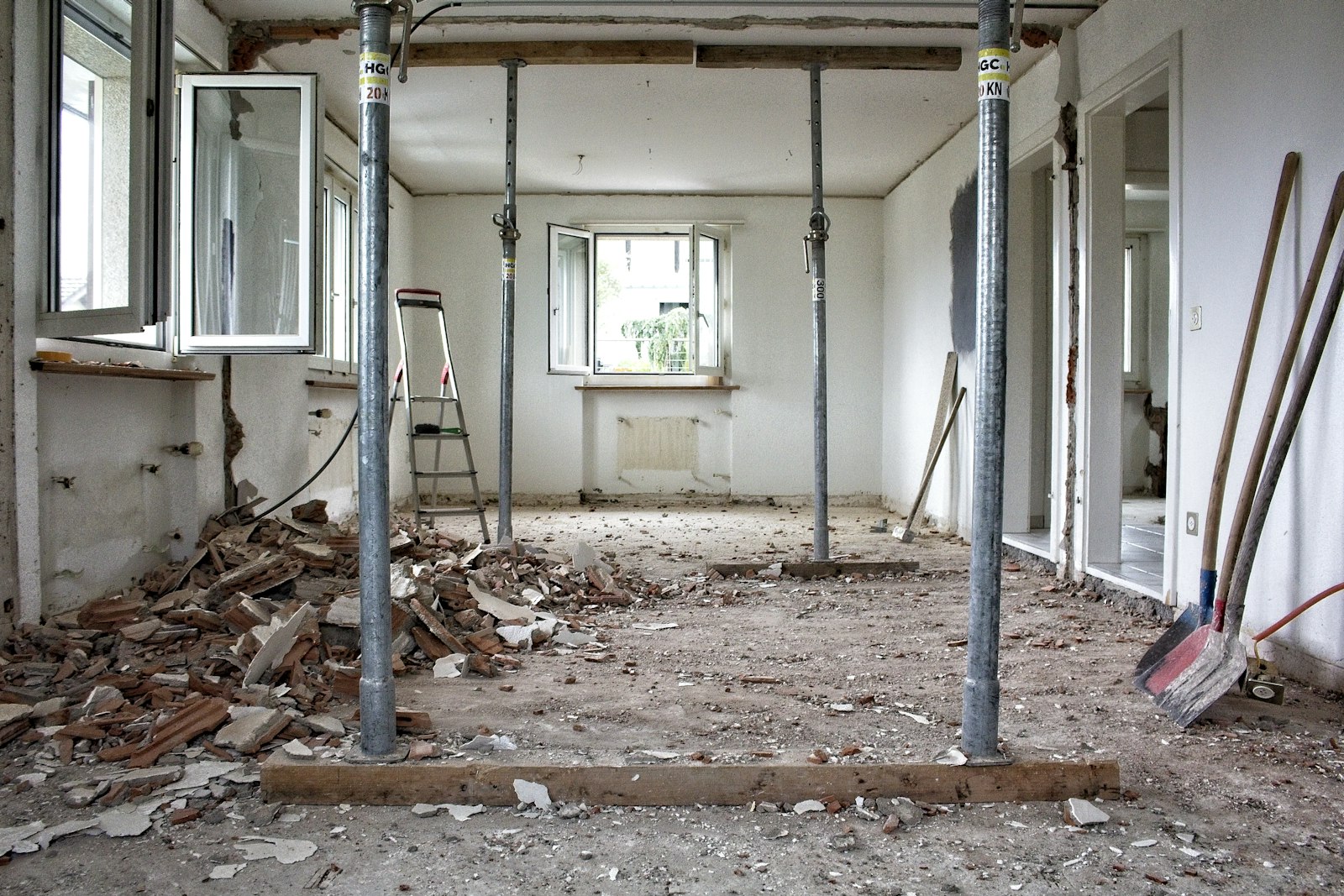 Gutted room mid strip-out with structural props and rubble